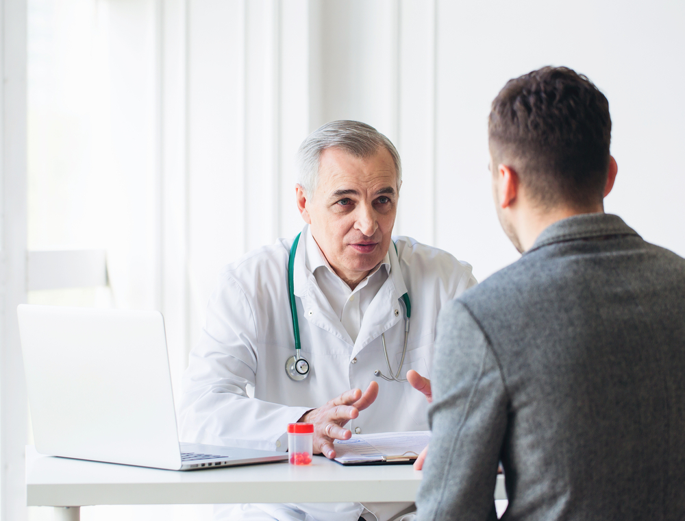 A doctor at a low cost Los Angeles clinic discusses Kaposi's sarcoma with a patient.