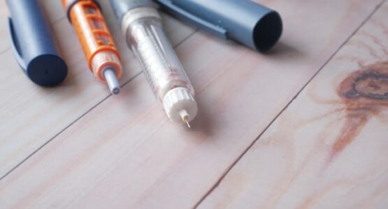 Pictured: 3 insulin syringes on light wood background