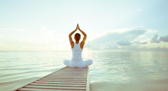 Women doing yoga by a lake