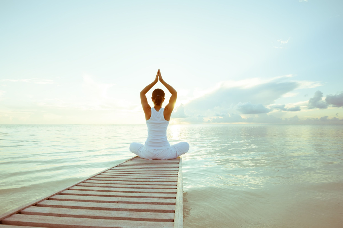 Women doing yoga by a lake