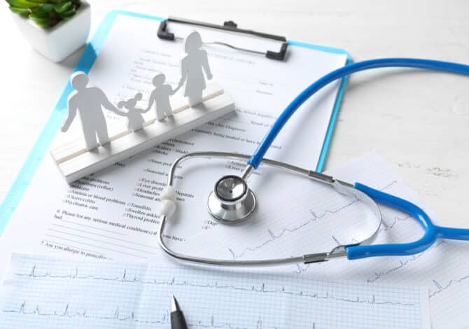 Composition,With,Family,Figure,And,Stethoscope,On,Wooden,Table.,Health