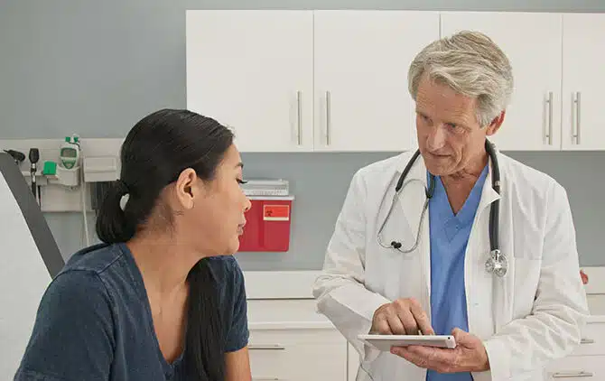 Older,Man,Doctor,Listening,To,Medical,History,From,Japanese,Woman