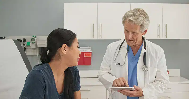 Older,Man,Doctor,Listening,To,Medical,History,From,Japanese,Woman